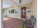 A covered front porch featuring neutral stucco exterior, brick pavers and decorative front door at 715 45Th Ne Ave, St Petersburg, FL 33703