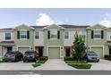 View of multiple modern townhomes, each with a driveway and well-kept front yard landscaping at 11054 Crescent Deer Dr, Land O Lakes, FL 34638