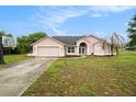 Charming one-story home featuring a two-car garage, well-manicured lawn, and a basketball hoop on the side at 12214 Buckingham Way, Spring Hill, FL 34609