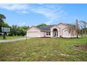 Charming one-story home with a two-car garage, a well-maintained lawn, and attractive front yard landscaping at 12214 Buckingham Way, Spring Hill, FL 34609