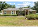 Charming single-story home with a well-manicured lawn and mature landscaping at 12436 Oak St, San Antonio, FL 33576