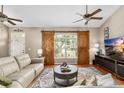 Bright living room featuring sliding barn door, plush seating and a ceiling fan at 12436 Oak St, San Antonio, FL 33576