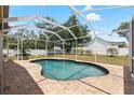Backyard with screened-in pool area, brick patio and a spacious lawn at 12436 Oak St, San Antonio, FL 33576