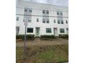 Townhome community displaying modern facades with green doors and landscaped walkways at 1330 W Gray St # 2, Tampa, FL 33606