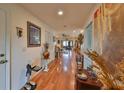 Inviting hallway with wood floors and artistic decor leading to open living spaces at 1417 Langley Dr, Sun City Center, FL 33573