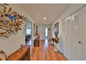 Bright hallway with wood floors, closet, and art leading into a bedroom with ceiling fan at 1417 Langley Dr, Sun City Center, FL 33573