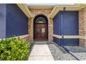 Close up of an arched entryway with stone accents leading to a striking, double front door at 1741 Beaconsfield Dr, Wesley Chapel, FL 33543