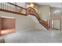 Spacious foyer with soaring ceilings, a wooden staircase, and large tile flooring at 1808 Sawhorse Ct, Lutz, FL 33559