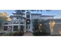 Stately two-story home featuring a grand entrance, manicured landscaping, and decorative palm trees at 1931 Oak Ridge Ct, Clearwater, FL 33759