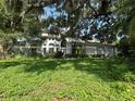 Charming two-story home with a well-manicured lawn, mature landscaping, and shade trees at 1931 Oak Ridge Ct, Clearwater, FL 33759