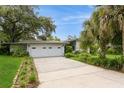 Charming single-story home featuring a two-car garage, well-maintained landscaping, and a concrete driveway at 2035 Nolan Dr, Dunedin, FL 34698
