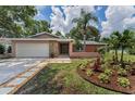 Single-story home with lush landscaping, stone accents, and a well-manicured front yard at 2063 Ridgecrest Dr, Dunedin, FL 34698