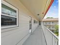 Spacious balcony with white railing, accessible hallway, and view of the surrounding community at 2261 Swedish Dr # 47, Clearwater, FL 33763