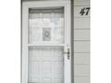 Close-up of the unit's front door with a screen door and decorative hanger at 2261 Swedish Dr # 47, Clearwater, FL 33763