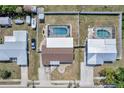 Aerial view of a fenced property featuring a screened-in pool and a well-maintained lawn at 260 Venice East Blvd, Venice, FL 34293