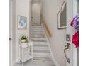 Bright entryway with a staircase featuring painted wood, a decorative mirror, and a charming side table at 3147 Oyster Bayou Way, Clearwater, FL 33759
