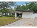 Well-maintained single-story home featuring a landscaped front yard with a driveway at 4609 S Lois Ave, Tampa, FL 33611