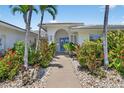 Charming home featuring a tiled roof, arched entryway and colorful tropical landscaping at 511 Island Way, Clearwater Beach, FL 33767
