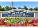 Beautifully landscaped Twin Lakes of Brandon community sign with vibrant flowers in the foreground at 5117 Whispering Leaf Trl, Valrico, FL 33596