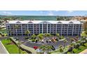 Exterior elevation of condo building, lush landscaping, and ample parking at 5445 Gulf Blvd # 210, St Pete Beach, FL 33706