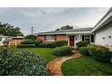 Charming home with a red door, brick facade, landscaped yard, and a stone pathway at 5919 35Th N Ave, St Petersburg, FL 33703