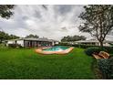 Backyard pool with brick surround and seating area surrounded by lush green lawn at 5919 35Th N Ave, St Petersburg, FL 33703
