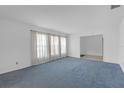 Bright living room with large windows, neutral walls, and a seamless transition to other rooms at 7002 Doreen St, Tampa, FL 33617