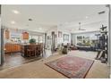 A spacious living room features an area rug, a ceiling fan, and a seamless transition to the kitchen at 8217 Canterbury Lake Blvd, Tampa, FL 33619
