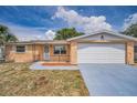 Charming single-story home featuring a front yard, attached garage, and desert-friendly landscaping at 9100 Lunar Ln, Port Richey, FL 34668