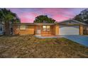 Charming single-story home featuring a front yard, attached garage, and desert-friendly landscaping at 9100 Lunar Ln, Port Richey, FL 34668