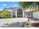 Beautiful home with double door entrance, arched windows, white columns, and paved driveway at 9276 Ashley Dr, Weeki Wachee, FL 34613