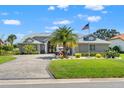 Attractive single-story house with paved driveway, vibrant green lawn, and mature palm tree at 9276 Ashley Dr, Weeki Wachee, FL 34613
