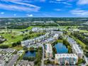 Expansive aerial view of condos nestled within lush greenery, golf course, waterways, and community pool at 960 Starkey Rd # 9104, Largo, FL 33771