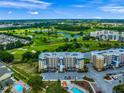 Scenic aerial shot of blue and beige condos by a verdant golf course and sparkling blue community pool at 960 Starkey Rd # 9104, Largo, FL 33771