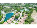 Aerial image showcases a community with lovely lake, tennis courts, pool, and lush green spaces, with house marked by an arrow at 11121 Cherrywood Ct, Spring Hill, FL 34609