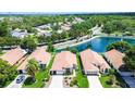 An aerial view shows a well-maintained home in a desirable neighborhood with mature trees and a tranquil lake at 11121 Cherrywood Ct, Spring Hill, FL 34609