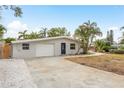 Beautiful home featuring a well-kept lawn, driveway, and quaint single-story facade at 12 Bayou Ln, Palm Harbor, FL 34683