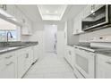 The modern kitchen features white cabinets, stainless steel appliances, and granite countertops at 13612 S Village Dr # 5201, Tampa, FL 33618