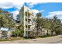The exterior showcases modern architecture, multiple balconies, and lush landscaping surrounded by mature trees at 1501 Doyle Carlton Dr # 303, Tampa, FL 33602