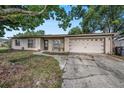 Charming single-story brick home with an attached garage and mature trees shading the front at 15820 Sapwood St, Tampa, FL 33624