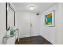 Entryway features wood floors, a glass table, and art, enhancing the stylish and inviting space at 1651 Sand Key Estates Ct # 54, Clearwater Beach, FL 33767