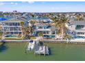 Stunning aerial view of the home with a private dock, boat lift, and a sparkling backyard pool at 17077 Dolphin Dr, North Redington Beach, FL 33708