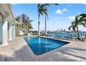 Inviting backyard pool featuring clear water, brick pavers, and views of the bay at 17077 Dolphin Dr, North Redington Beach, FL 33708
