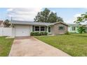 Welcoming one-story home with a manicured lawn, charming shutters, and a private driveway at 2020 Douglas Ave, Dunedin, FL 34698
