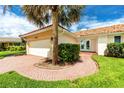 Charming home exterior featuring a brick walkway, well-maintained lawn, and a terra cotta tiled roof at 2096 Massachusetts Ne Ave, St Petersburg, FL 33703