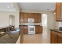Traditional kitchen with wooden cabinets, granite countertops, and white appliances at 2490 Kensington Greens Dr # 0, Sun City Center, FL 33573