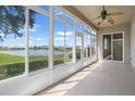 Enclosed lanai featuring scenic lake views, ceiling fan, and ample natural light at 2490 Kensington Greens Dr # 0, Sun City Center, FL 33573