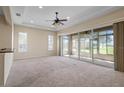 Spacious living room with neutral carpet, ceiling fan, and sliding glass doors at 2490 Kensington Greens Dr # 0, Sun City Center, FL 33573