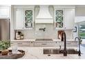 Modern kitchen boasts white cabinets, elegant backsplash, and a stylish pot filler faucet at 3724 Fawn Grove Ct, Land O Lakes, FL 34639