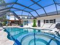 Backyard features a screened-in pool and spa, perfect for relaxation and entertaining at 3724 Fawn Grove Ct, Land O Lakes, FL 34639